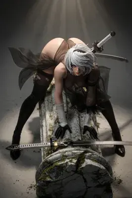 2B (YoRHa No.2 Type B) from NieR: Automata depicted in a gothic-lolita style outfit with a blindfold, posing over a broken stone structure.
