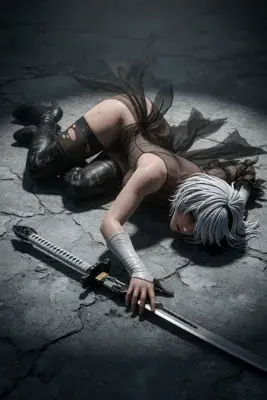 Fan art of 2B (YoRHa No.2 Type B) from NieR: Automata lying on cracked ground with a sword, wearing a black dress and blindfold.