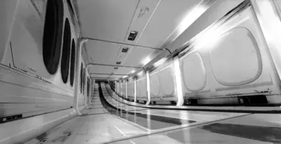 A black and white digital illustration of a futuristic corridor from NieR: Automata, featuring curved walkways and circular windows.