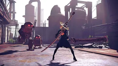 2B (YoRHa No.2 Type B) from NieR: Automata stands in a combat pose with a sword, facing robotic enemies in an industrial wasteland.