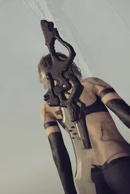 2B (YoRHa No.2 Type B) from NieR: Automata holding a sword in a dramatic low-angle pose.