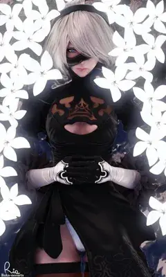 2B, the android from NieR:Automata, stands surrounded by white flowers.